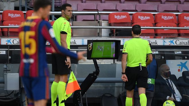 Árbitro revisando el VAR ante una jugada con el Barça